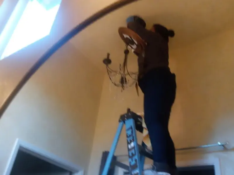 Electrician installing a chandelier in a King residence